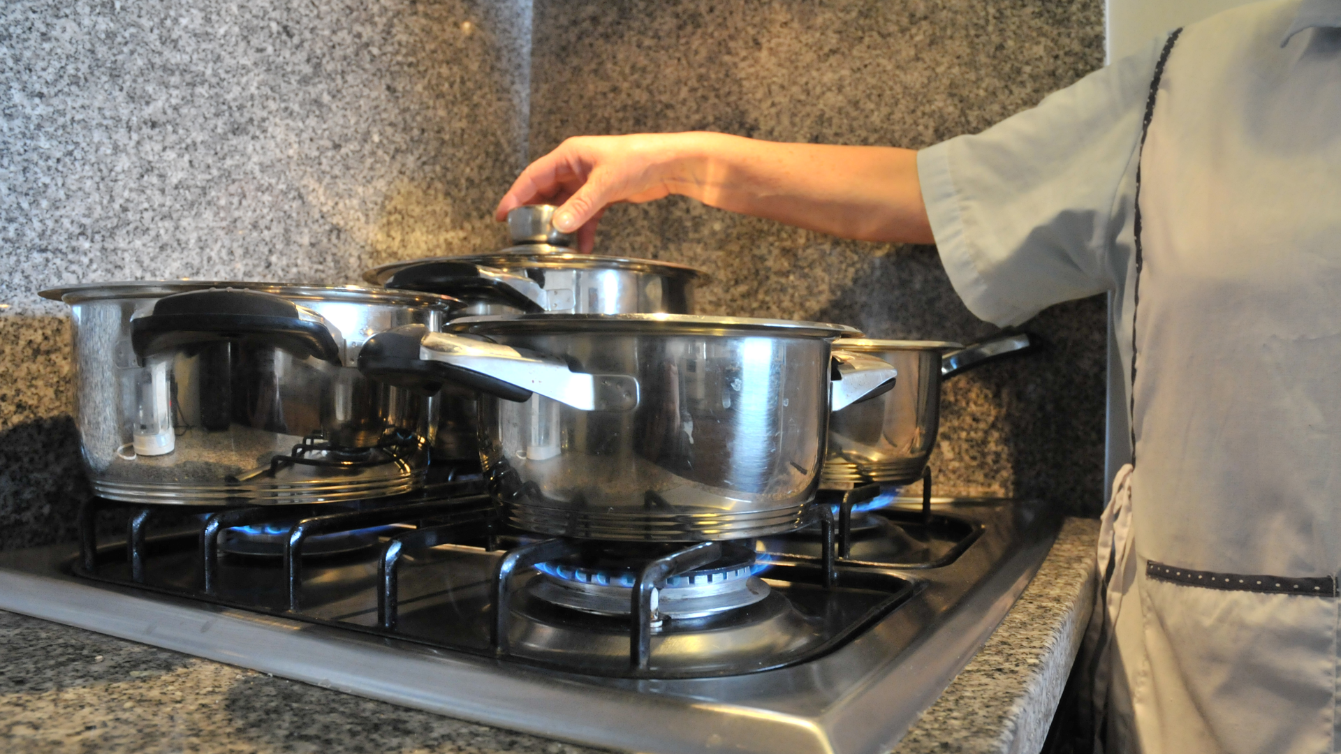 Persona cocinando en una estufa con ollas