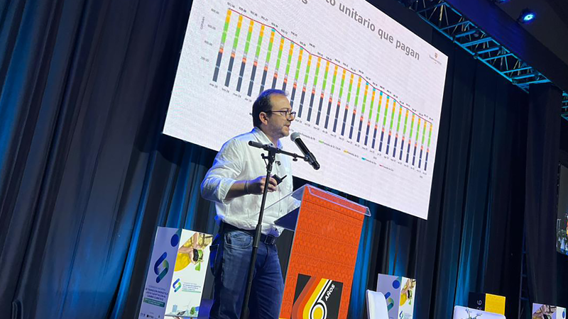 Un hombre de pie en un podio, presentando información a una audiencia.